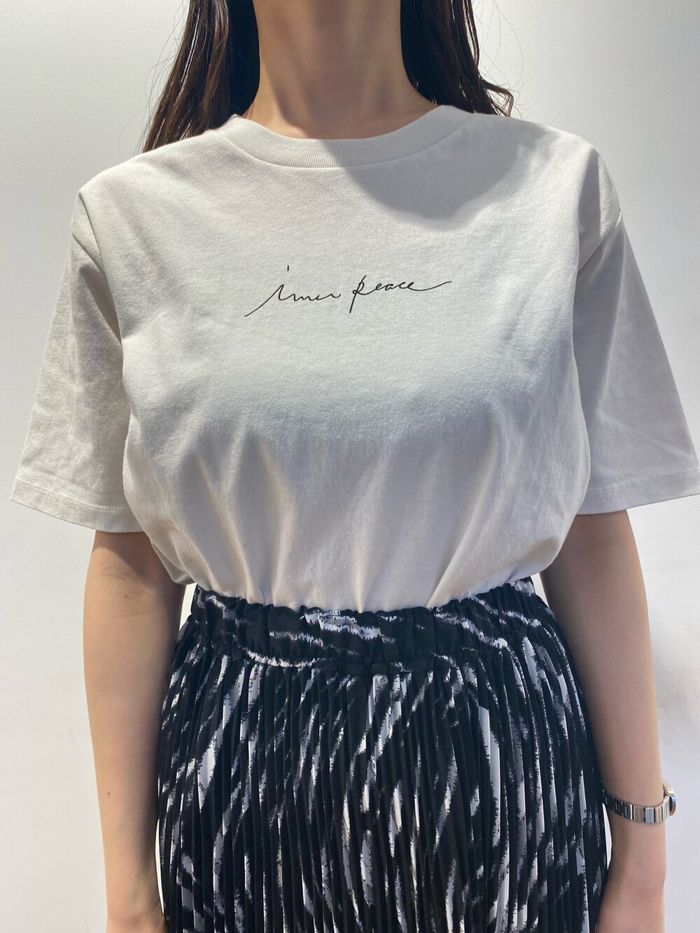 ブラック系のスカート、ベージュ系のその他アウター、ホワイト系のサンダルを着用したレディースの春コーディネートの3枚目の写真