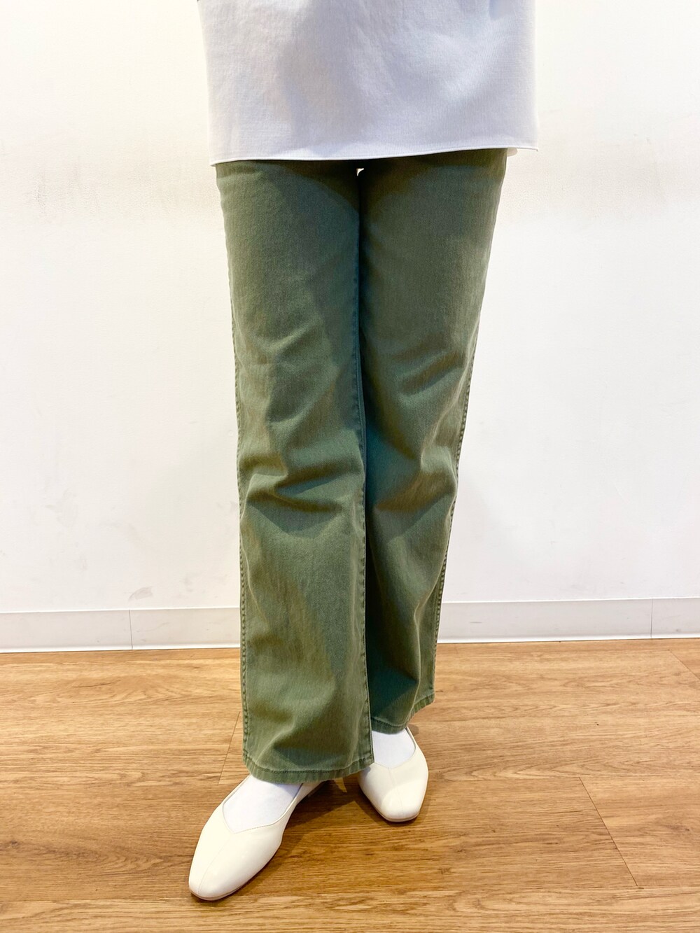 ブラウン系のトートバッグ、グリーン系のニット/セーター、グリーン系のデニムパンツを着用したレディースの冬コーディネートの5枚目の写真