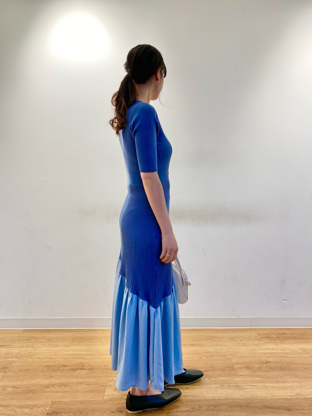 ブルー系のワンピース、ホワイト系のショルダーバッグ、ブラック系のその他シューズを着用したレディースの春コーディネートの2枚目の写真