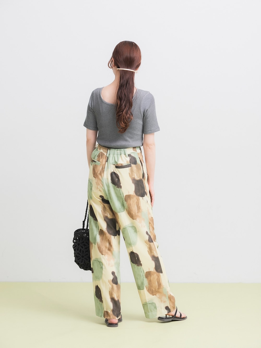 ブラック系のTシャツ/カットソー、イエロー系のその他パンツ、ブラック系のかごバッグを着用したレディースの春コーディネートの3枚目の写真