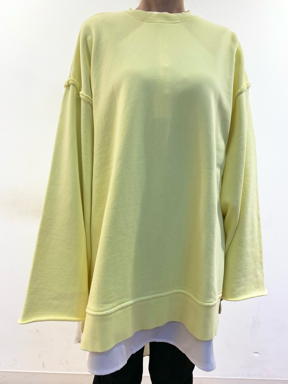 イエロー系のスウェット、ブラック系のトートバッグ、ホワイト系のシャツ/ブラウスを着用したレディースの冬コーディネートの3枚目の写真