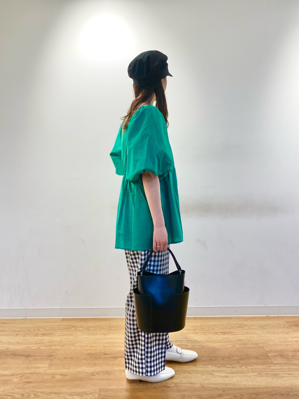 グリーン系のシャツ/ブラウス、ホワイト系のローファー、ブラック系のトートバッグを着用したレディースの春コーディネートの2枚目の写真