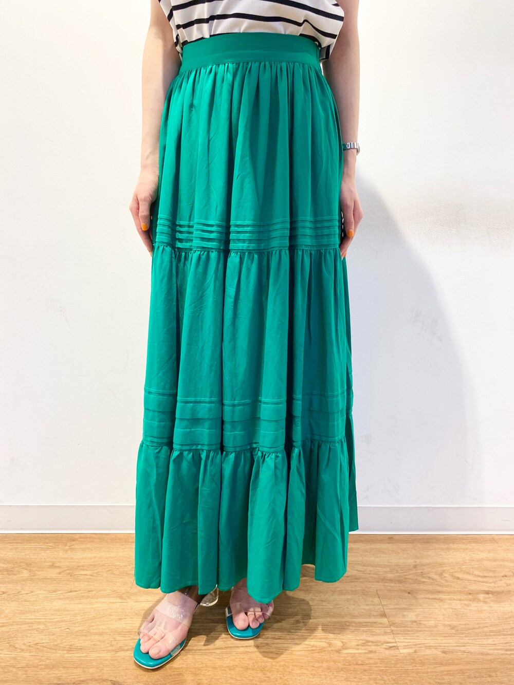 ホワイト系のTシャツ/カットソー、グリーン系のスカート、グリーン系のサンダルを着用したレディースの春コーディネートの5枚目の写真