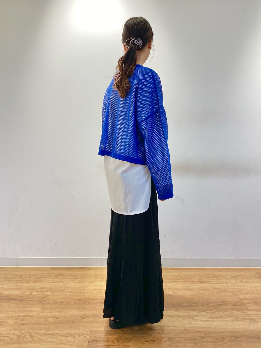 ブルー系のカーディガン/ボレロ、ホワイト系のTシャツ/カットソー、ブラック系のサンダルを着用したレディースの春コーディネートの2枚目の写真