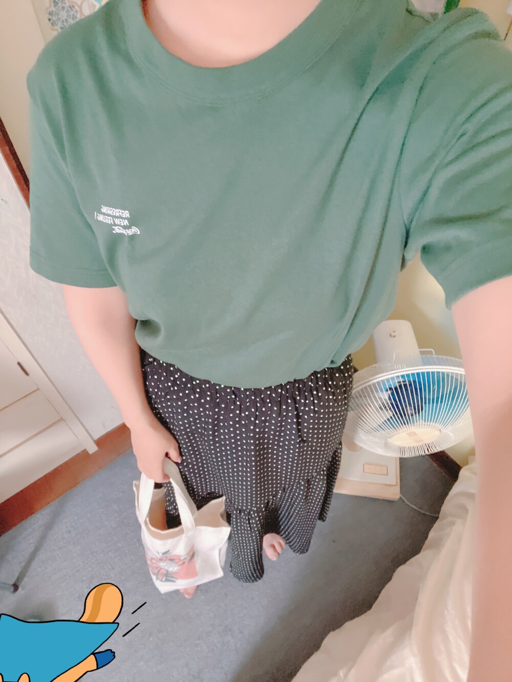 グリーン系のTシャツ/カットソー、レッド系のトートバッグ、ブラック系のスカートを着用したレディースの夏コーディネートの2枚目の写真