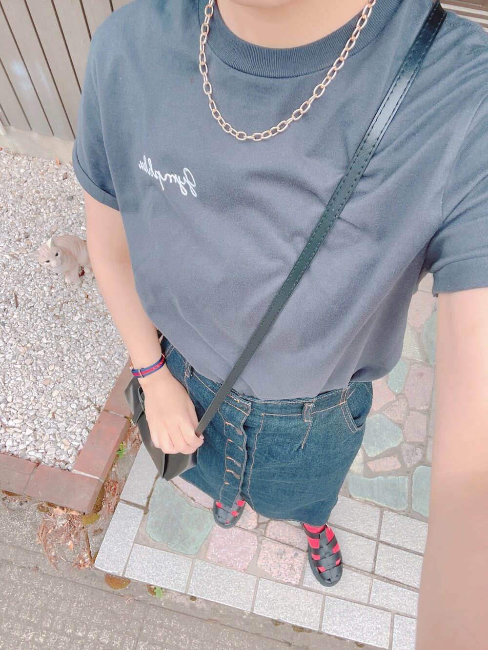 ブラック系のTシャツ/カットソー、ブルー系のスカート、ブラック系のサンダルを着用したレディースの夏コーディネートの2枚目の写真