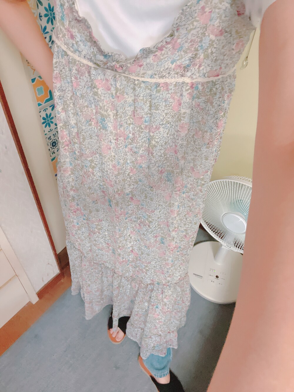 ピンク系のワンピース、ブルー系のデニムパンツ、ブラック系のサンダルを着用したレディースの夏コーディネートの2枚目の写真