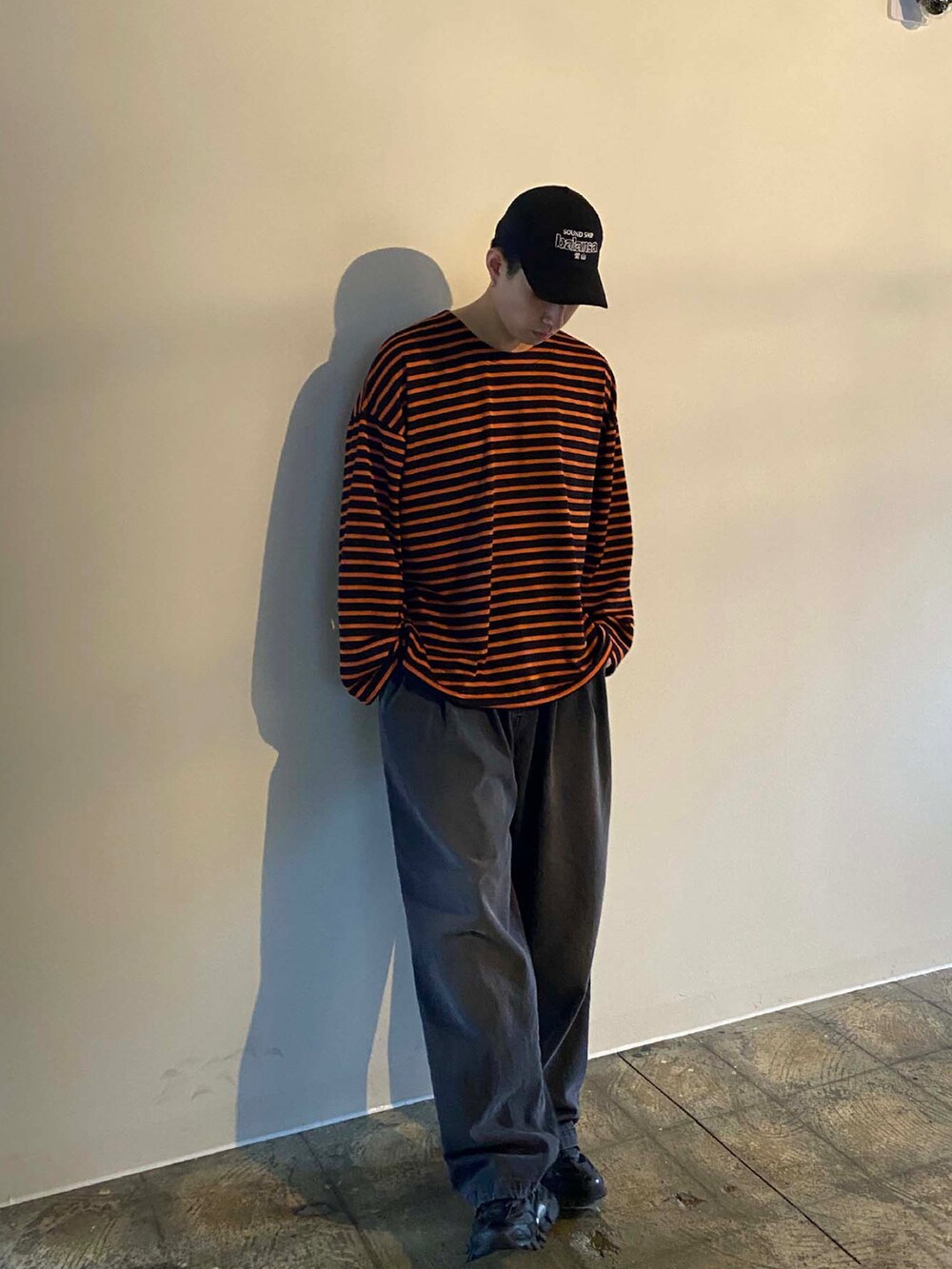 オレンジ系のTシャツ/カットソー、ブラック系のスニーカーを着用したメンズの春コーディネートの2枚目の写真