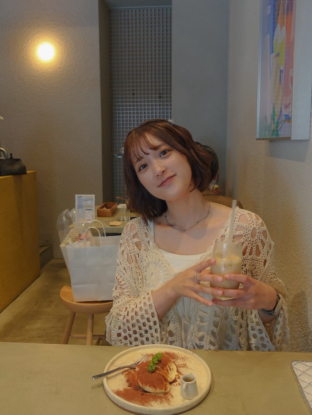 グレー系のスラックス、シルバー系のトートバッグ、ベージュ系のカーディガン/ボレロを着用したレディースの夏コーディネートの3枚目の写真