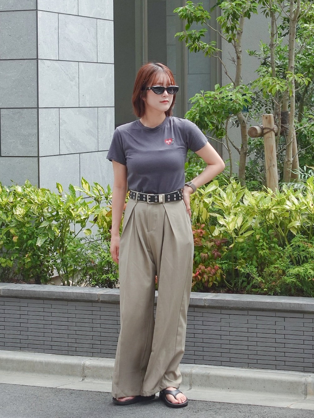 グレー系のTシャツ/カットソー、ベージュ系のスラックス、ブラック系のサンダルを着用したレディースの夏コーディネートの2枚目の写真