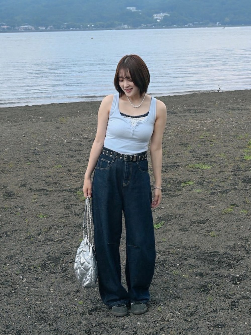 ブルー系のデニムパンツ、ブルー系のスニーカー、ブルー系のタンクトップを着用したレディースの夏コーディネートの4枚目の写真
