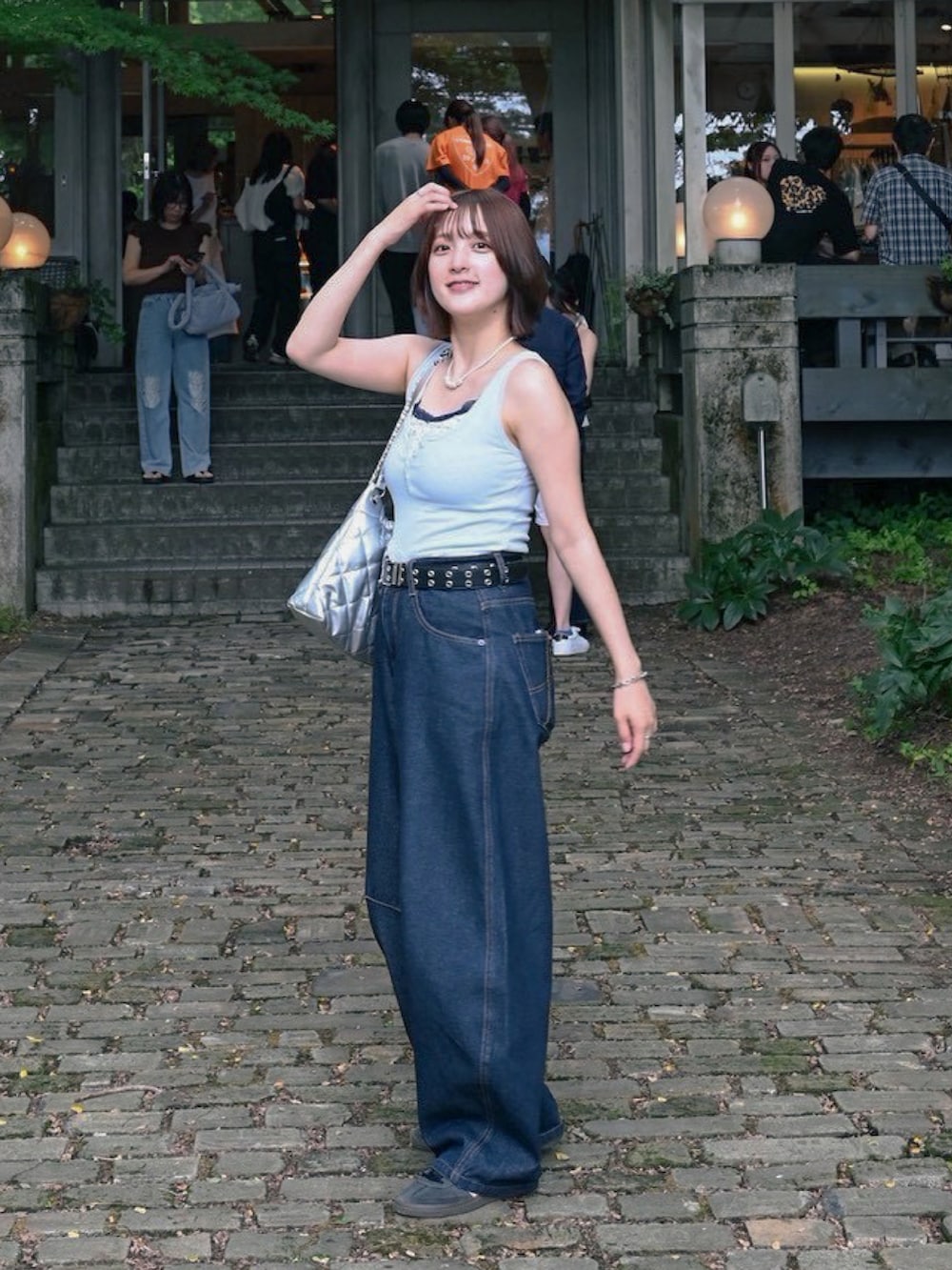 ブルー系のデニムパンツ、ブルー系のスニーカー、ブルー系のタンクトップを着用したレディースの夏コーディネートの3枚目の写真