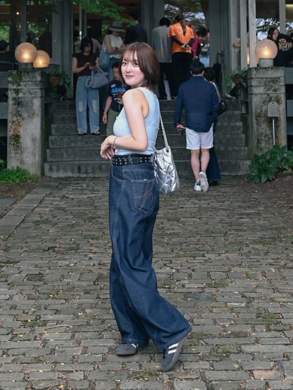 ブルー系のデニムパンツ、ブルー系のスニーカー、ブルー系のタンクトップを着用したレディースの夏コーディネートの2枚目の写真