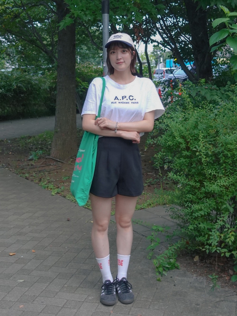 ブラック系のその他パンツ、グリーン系のトートバッグ、ホワイト系のTシャツ/カットソーを着用したレディースの夏コーディネートの2枚目の写真
