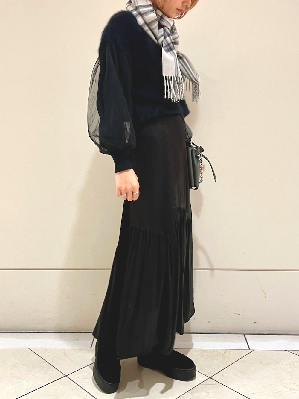 ブラック系のスニーカー、ブラック系のニット/セーター、グレー系のバッグを着用したレディースの冬コーディネートの2枚目の写真