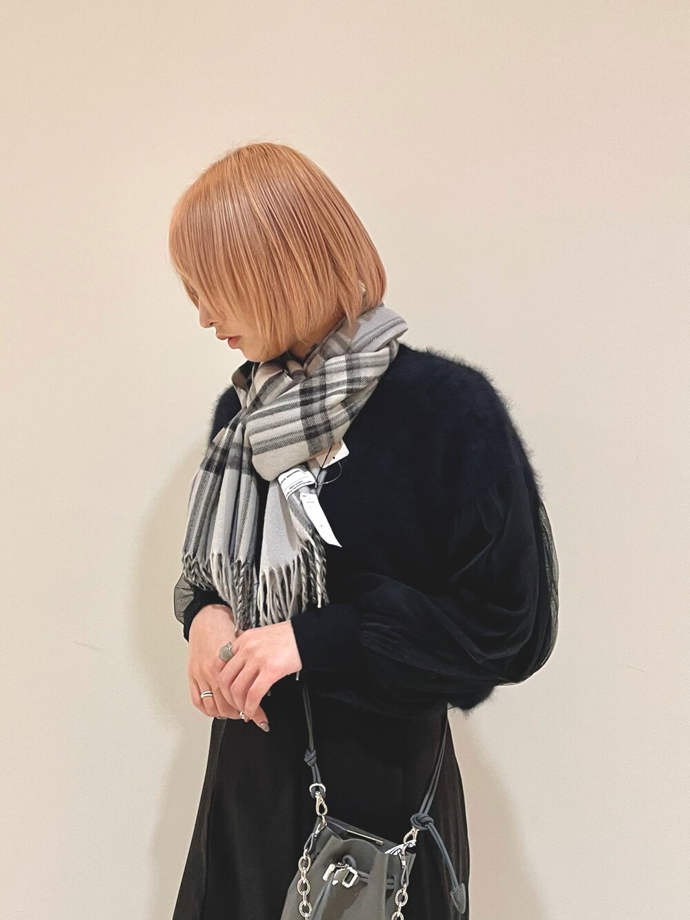 ブラック系のスニーカー、ブラック系のニット/セーター、グレー系のバッグを着用したレディースの冬コーディネートの3枚目の写真