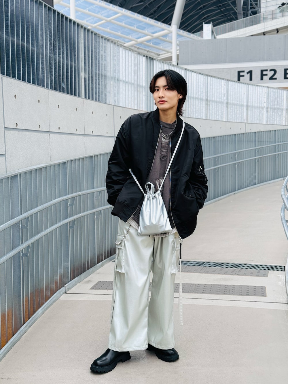 ブラック系のMA-1、シルバー系のショルダーバッグ、シルバー系のカーゴパンツを着用したメンズの春コーディネートの2枚目の写真