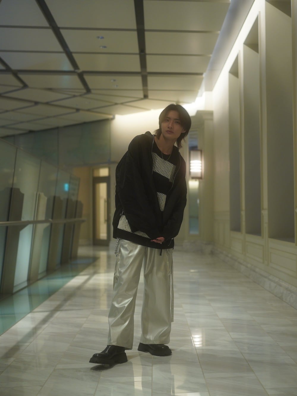 ブラック系のMA-1、ホワイト系のニット/セーター、シルバー系のカーゴパンツを着用したメンズの春コーディネートの3枚目の写真