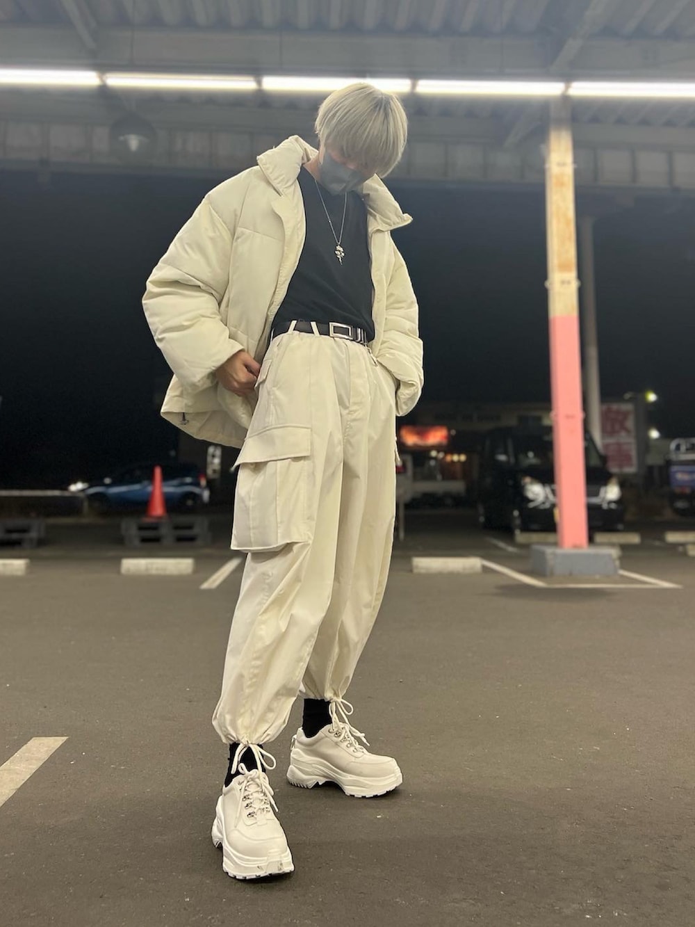 ホワイト系のダウンジャケット/コート、ブラック系のTシャツ/カットソー、ホワイト系のカーゴパンツを着用したメンズの冬コーディネートの3枚目の写真