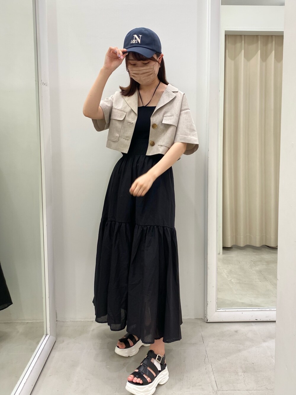 ブラック系のキャミソール、ホワイト系のテーラードジャケット、ブラック系のスカートを着用したレディースの夏コーディネートの2枚目の写真