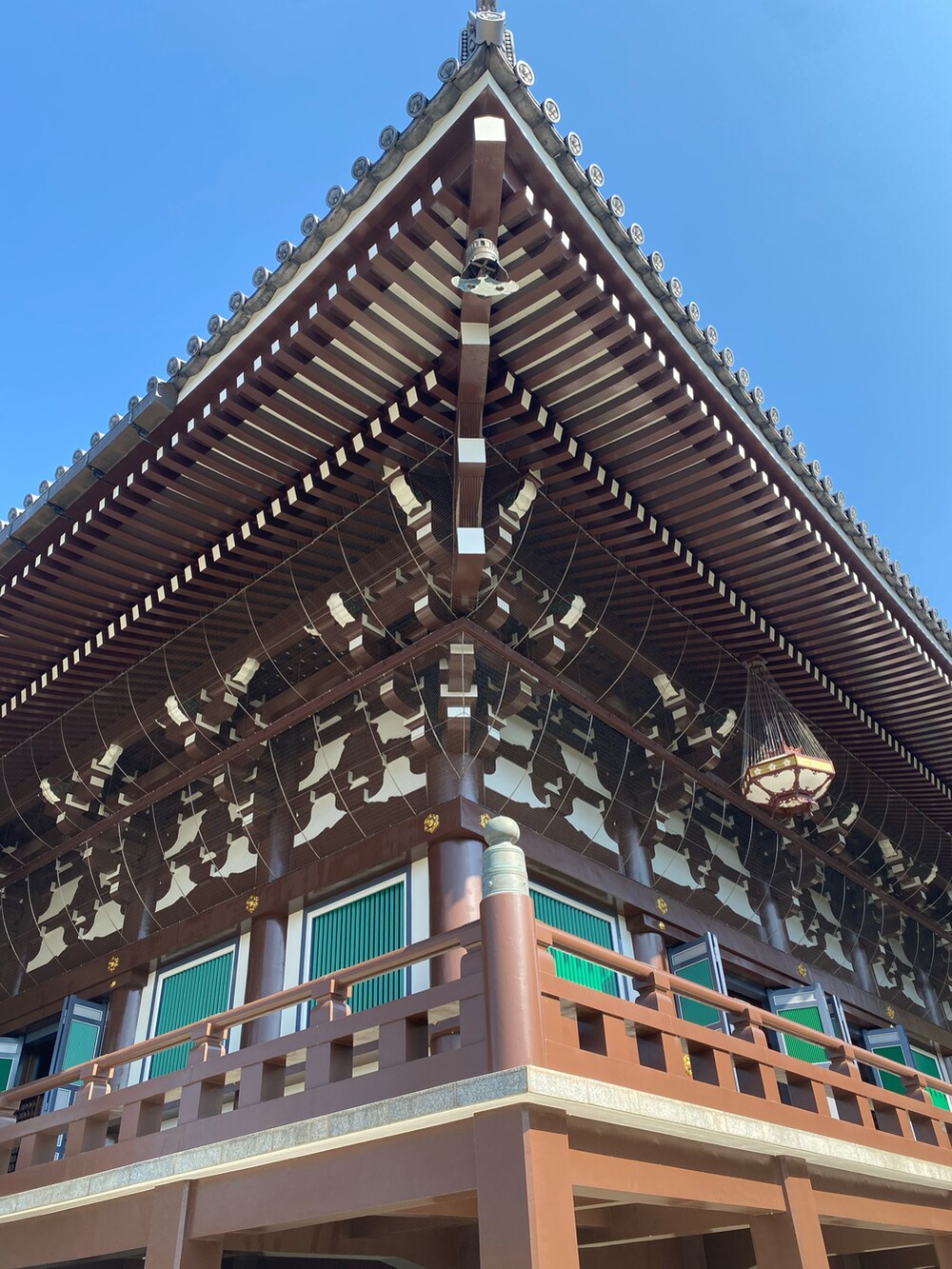 ベージュ系のバッグ、ブルー系のカーディガン/ボレロ、グリーン系のTシャツ/カットソーを着用したレディースの秋コーディネートの4枚目の写真