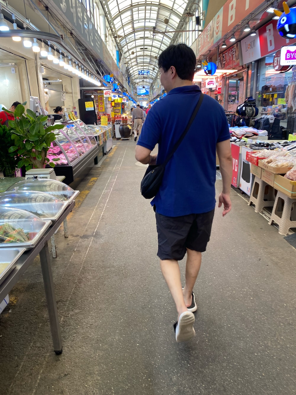 ブルー系のポロシャツ、ブラック系のその他パンツ、ブラック系のバッグを着用したメンズの秋コーディネートの3枚目の写真