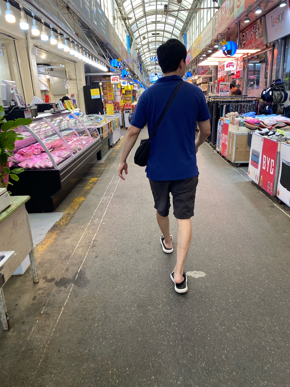 ブルー系のポロシャツ、ブラック系のその他パンツ、ブラック系のバッグを着用したメンズの秋コーディネートの2枚目の写真