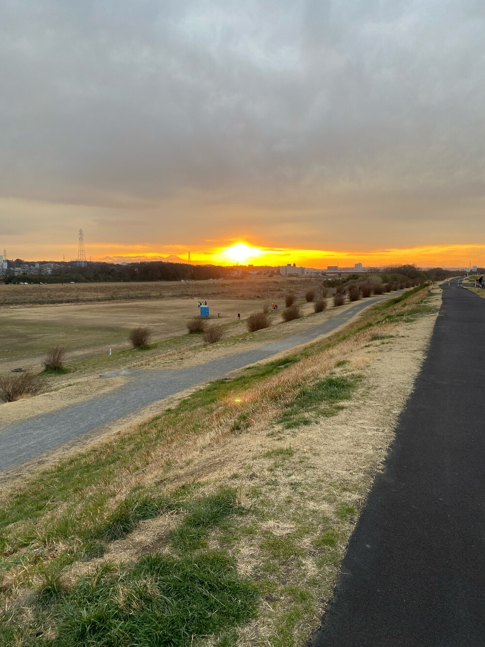 ベージュ系のステンカラーコート、ブルー系のカーディガン/ボレロ、ブルー系のその他パンツを着用したレディースの春コーディネートの3枚目の写真