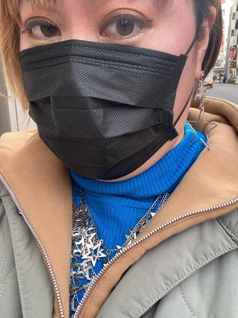 ベージュ系のスウェット、ブルー系のトップス、ブラック系のスウェットパンツを着用したレディースの春コーディネートの2枚目の写真