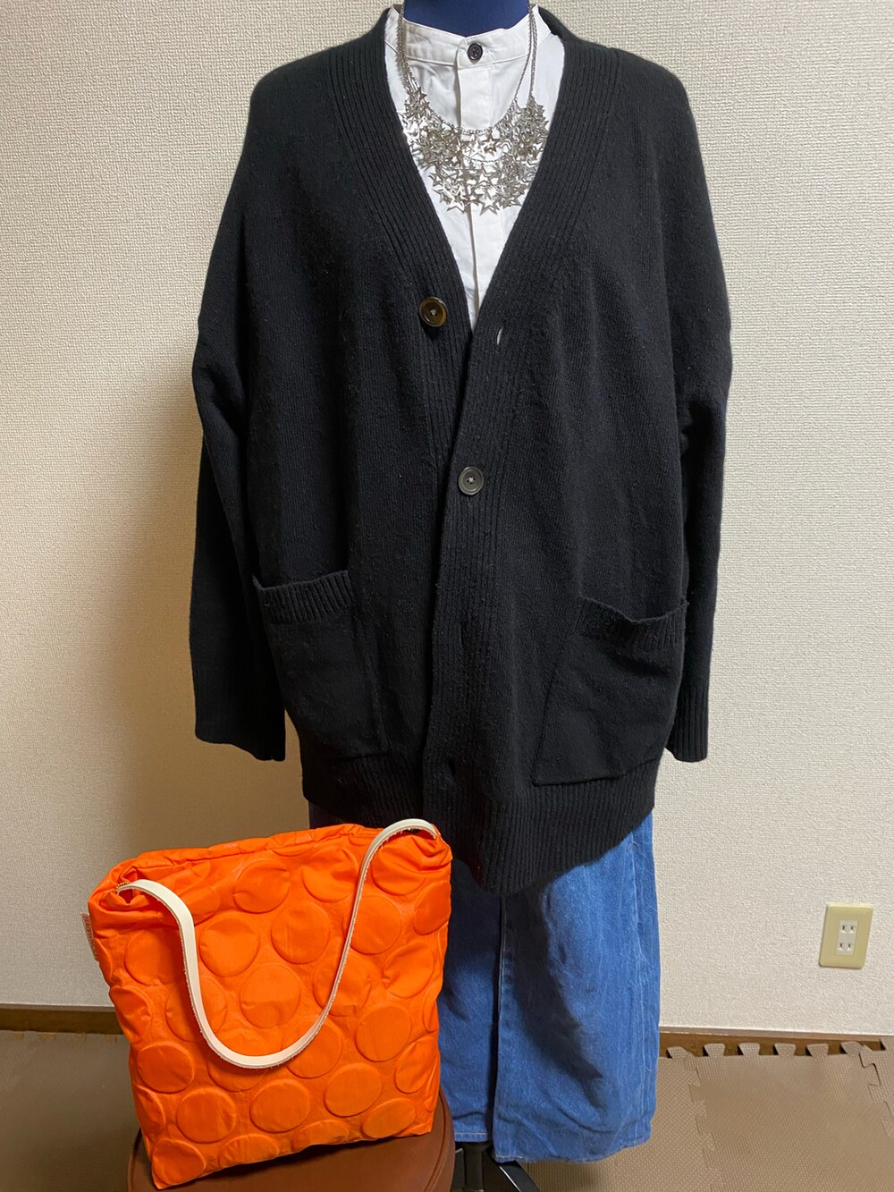 イエロー系のバッグ、ブラック系のカーディガン/ボレロ、ホワイト系のシャツ/ブラウスを着用したレディースの春コーディネートの2枚目の写真