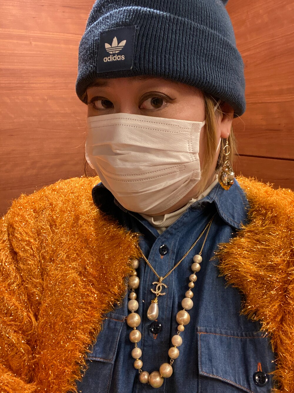 オレンジ系のカーディガン/ボレロ、ブルー系のシャツ/ブラウス、ブルー系のデニムパンツを着用したレディースの春コーディネートの2枚目の写真