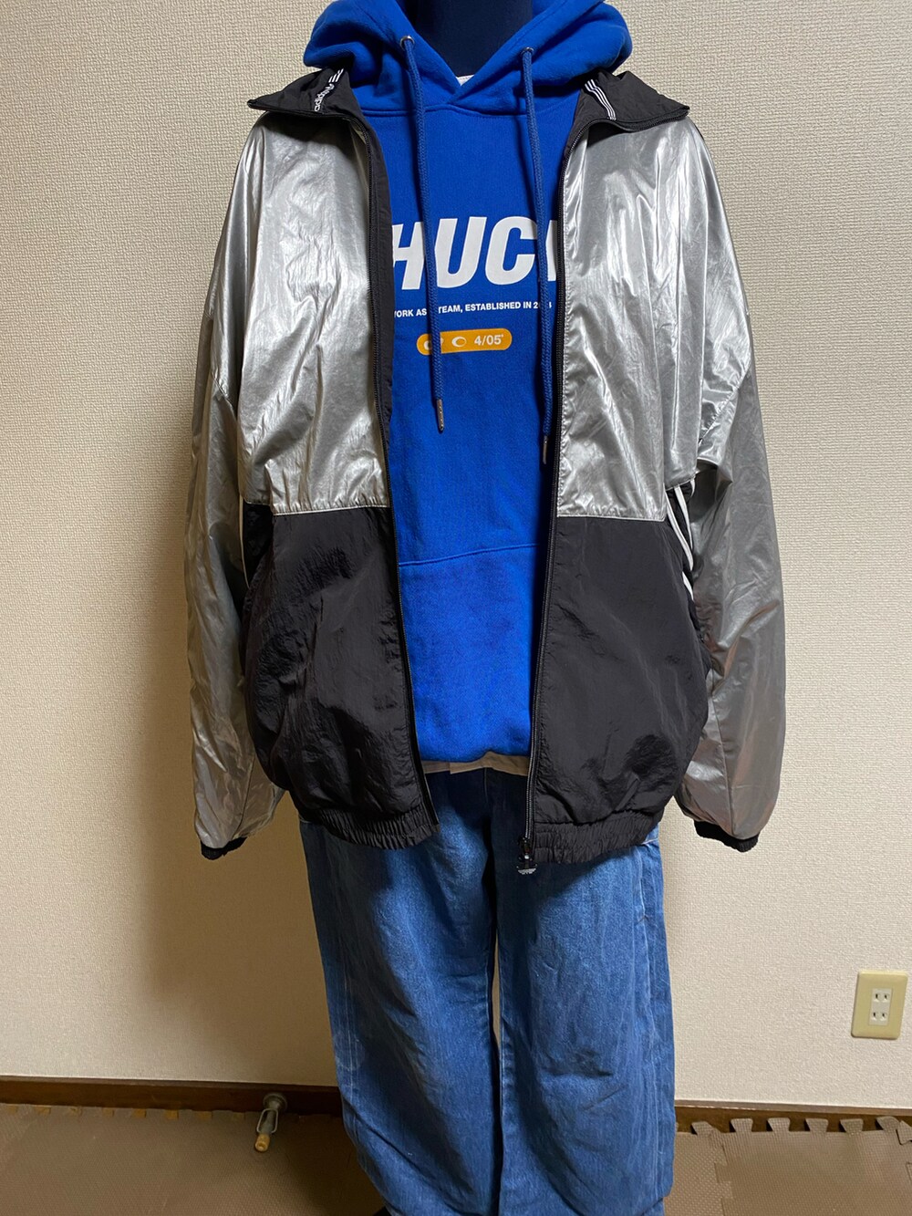 ブルー系のデニムパンツ、レッド系のバッグ、ブルー系のパーカーを着用したレディースの春コーディネートの2枚目の写真