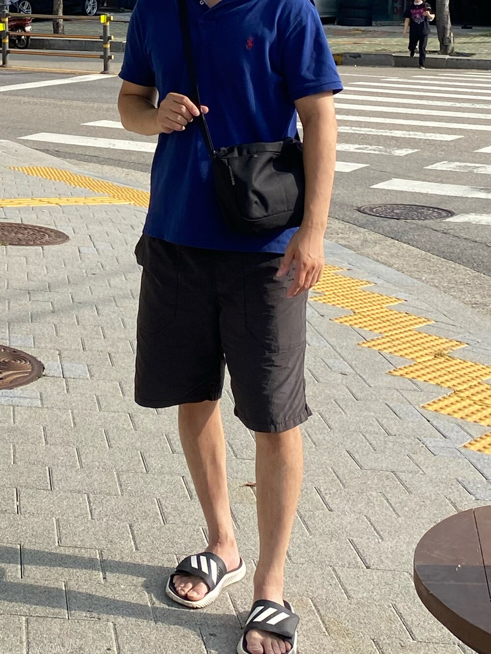 ブルー系のポロシャツ、ブラック系のその他パンツ、ブラック系のバッグを着用したメンズの秋コーディネートの4枚目の写真