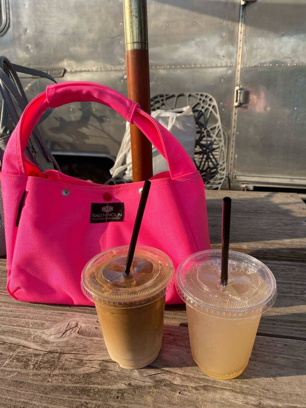 ピンク系のハンドバッグ、ベージュ系のステンカラーコート、グリーン系のカーディガン/ボレロを着用したレディースの春コーディネートの4枚目の写真