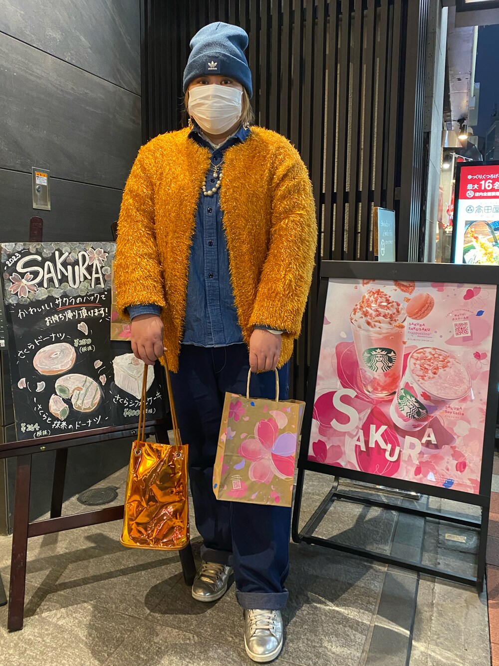 オレンジ系のカーディガン/ボレロ、ブルー系のシャツ/ブラウス、ブルー系のデニムパンツを着用したレディースの春コーディネートの3枚目の写真