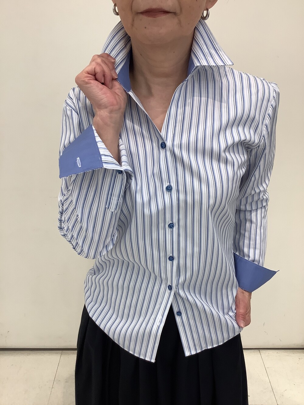 ブルー系のビジネスシャツを着用したレディースの春コーディネートの2枚目の写真