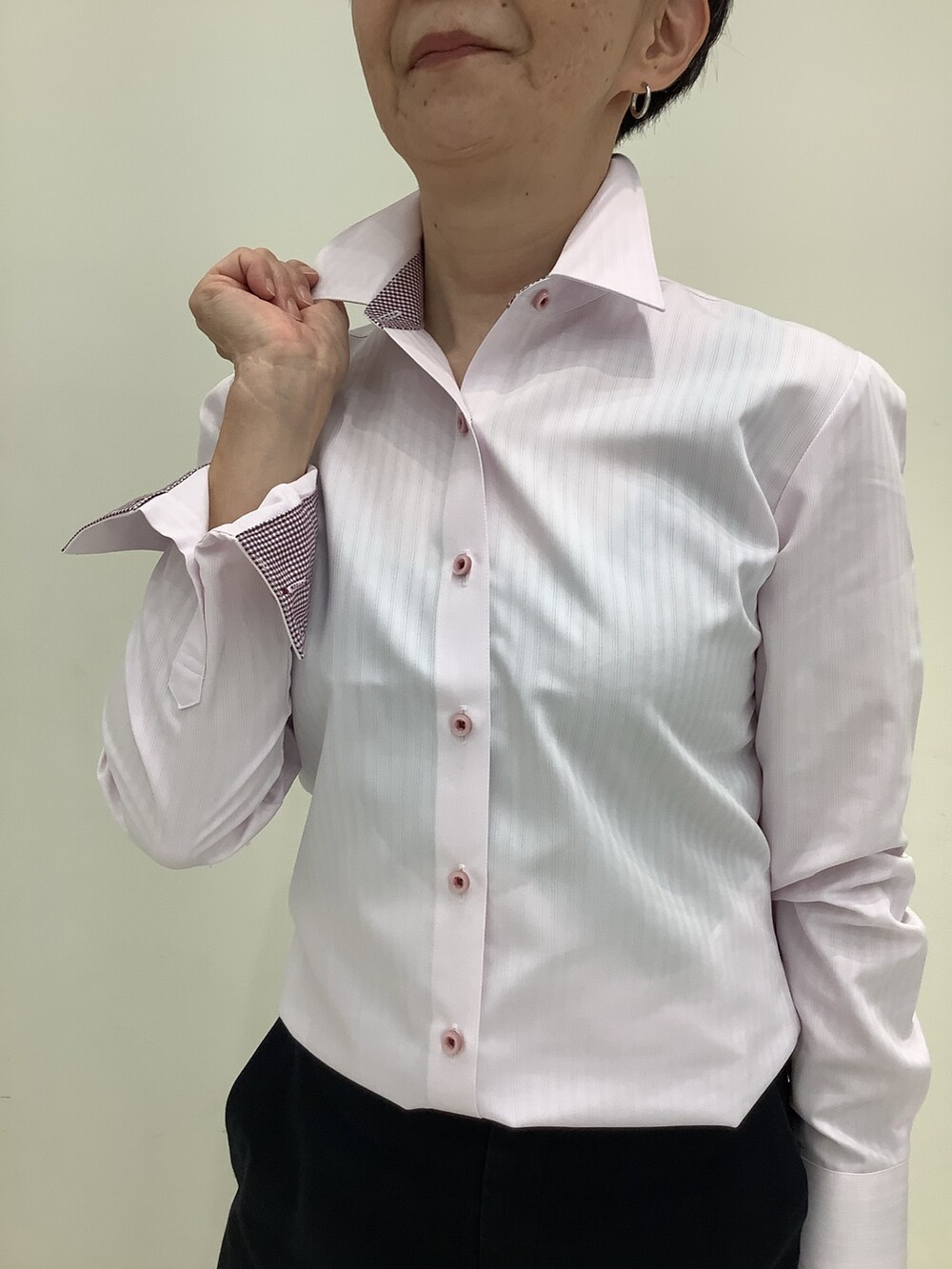 ピンク系のビジネスシャツを着用したレディースの秋コーディネートの2枚目の写真