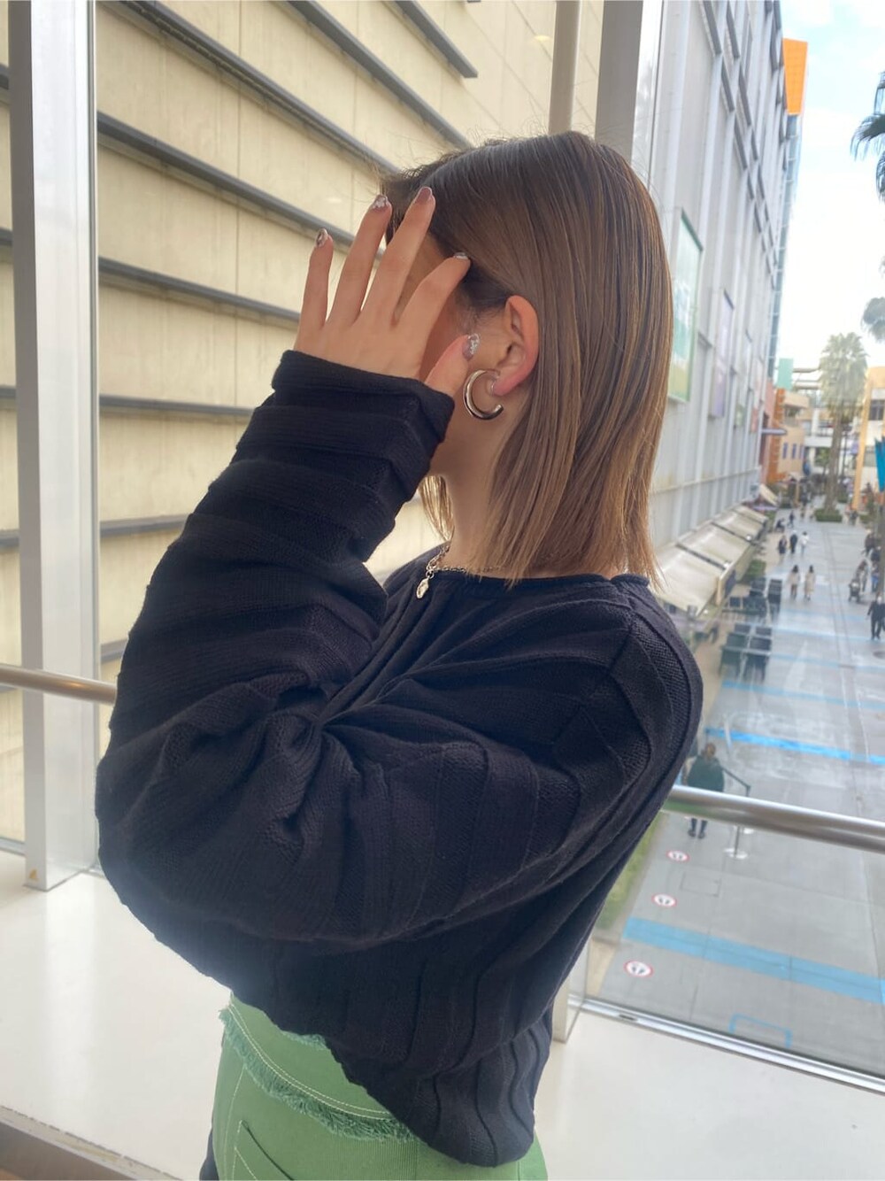 ブラック系のニット/セーター、ブラック系のブーツ、ブラック系のハンドバッグを着用したレディースの冬コーディネートの5枚目の写真