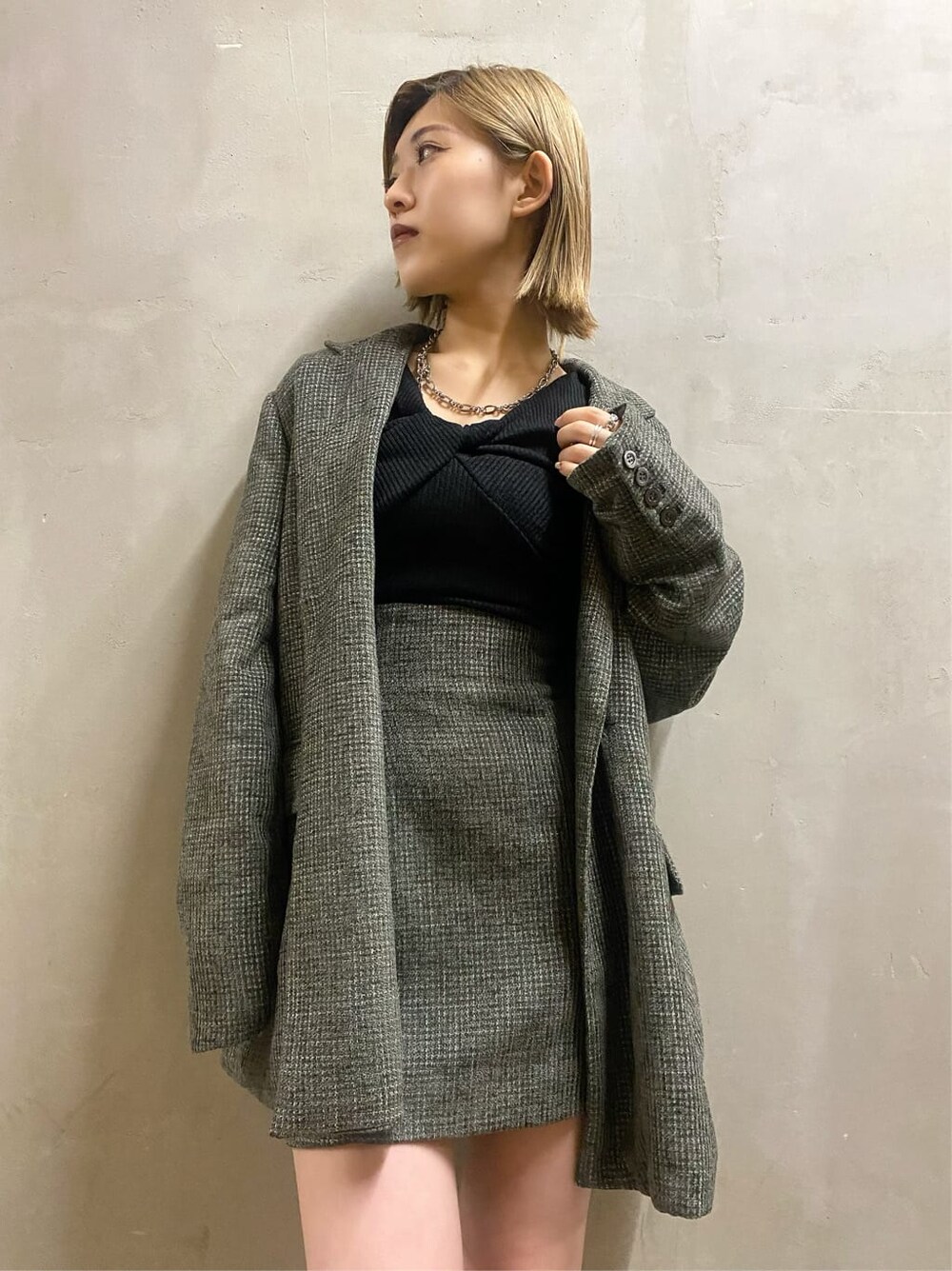 ベージュ系のテーラードジャケット、ベージュ系のスカート、ブラック系のブーツを着用したレディースの秋コーディネートの4枚目の写真