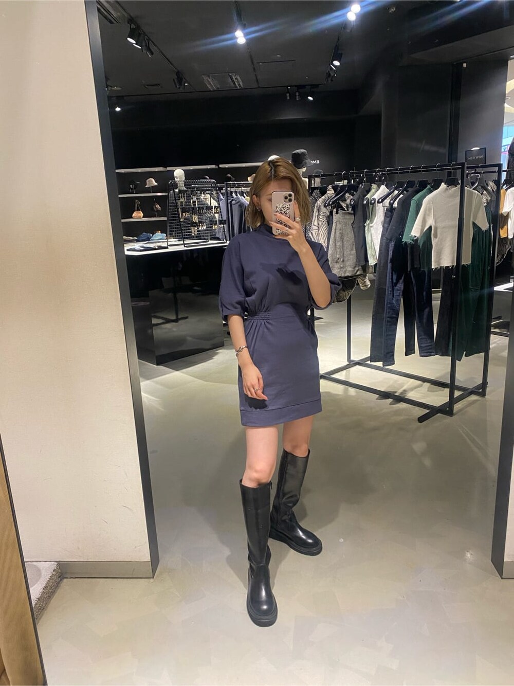 パープル系のワンピース、ブラック系のブーツを着用したレディースの秋コーディネートの4枚目の写真