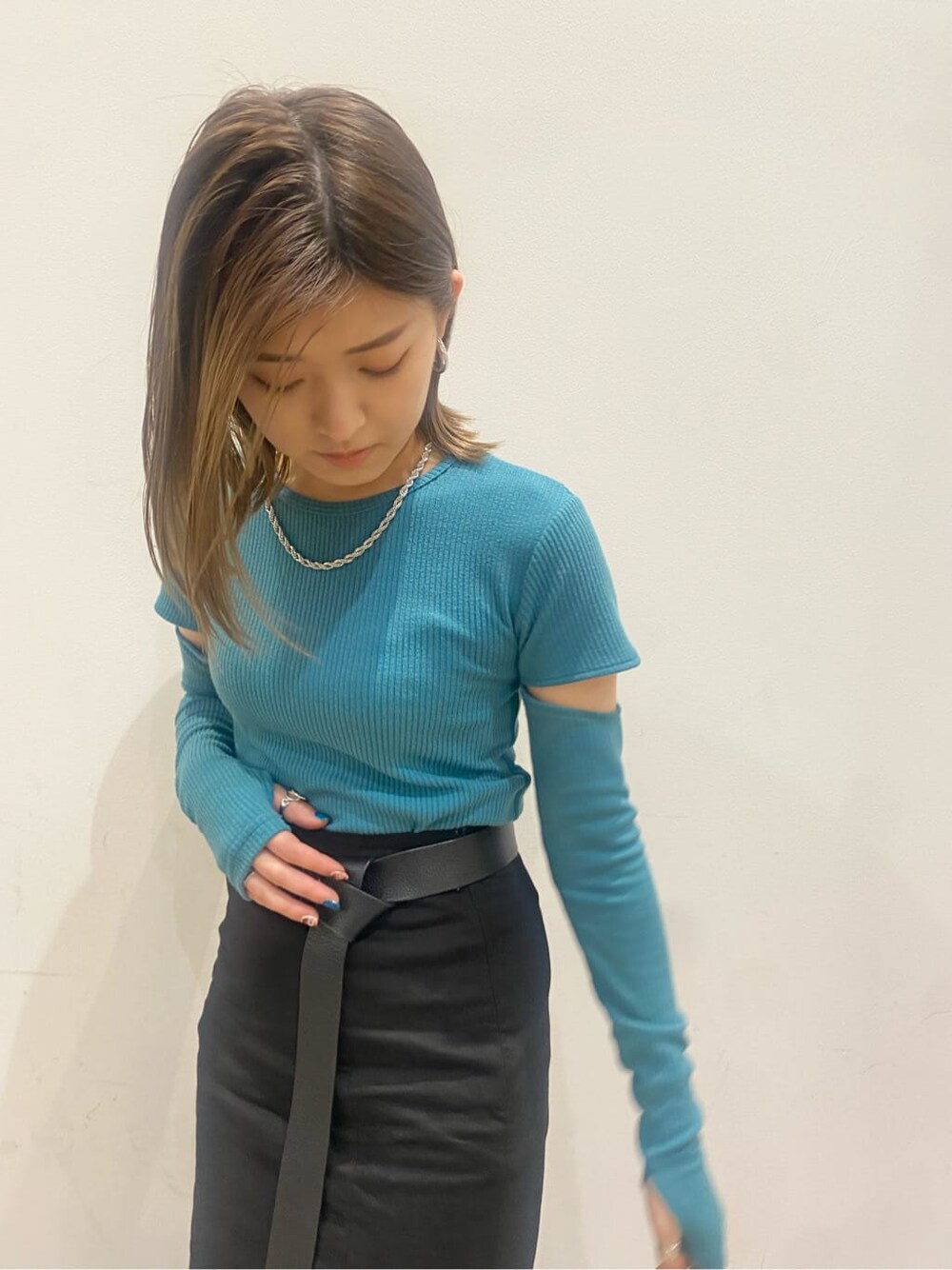 ブラック系のスカート、ブラック系のサンダル、ブルー系のTシャツ/カットソーを着用したレディースの春コーディネートの7枚目の写真