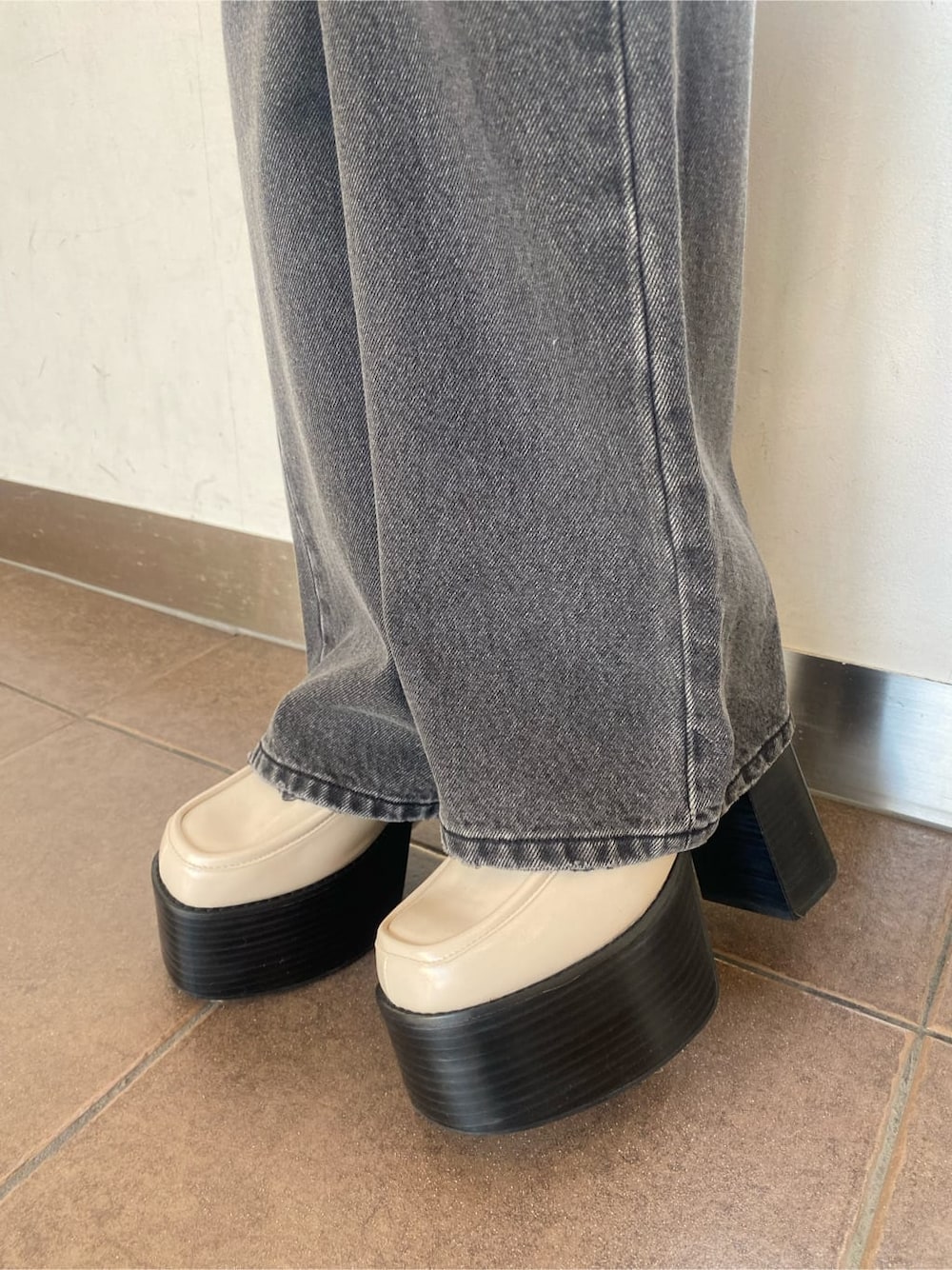 ホワイト系のローファー、グレー系のデニムパンツ、ブラウン系のシャツ/ブラウスを着用したレディースの冬コーディネートの7枚目の写真