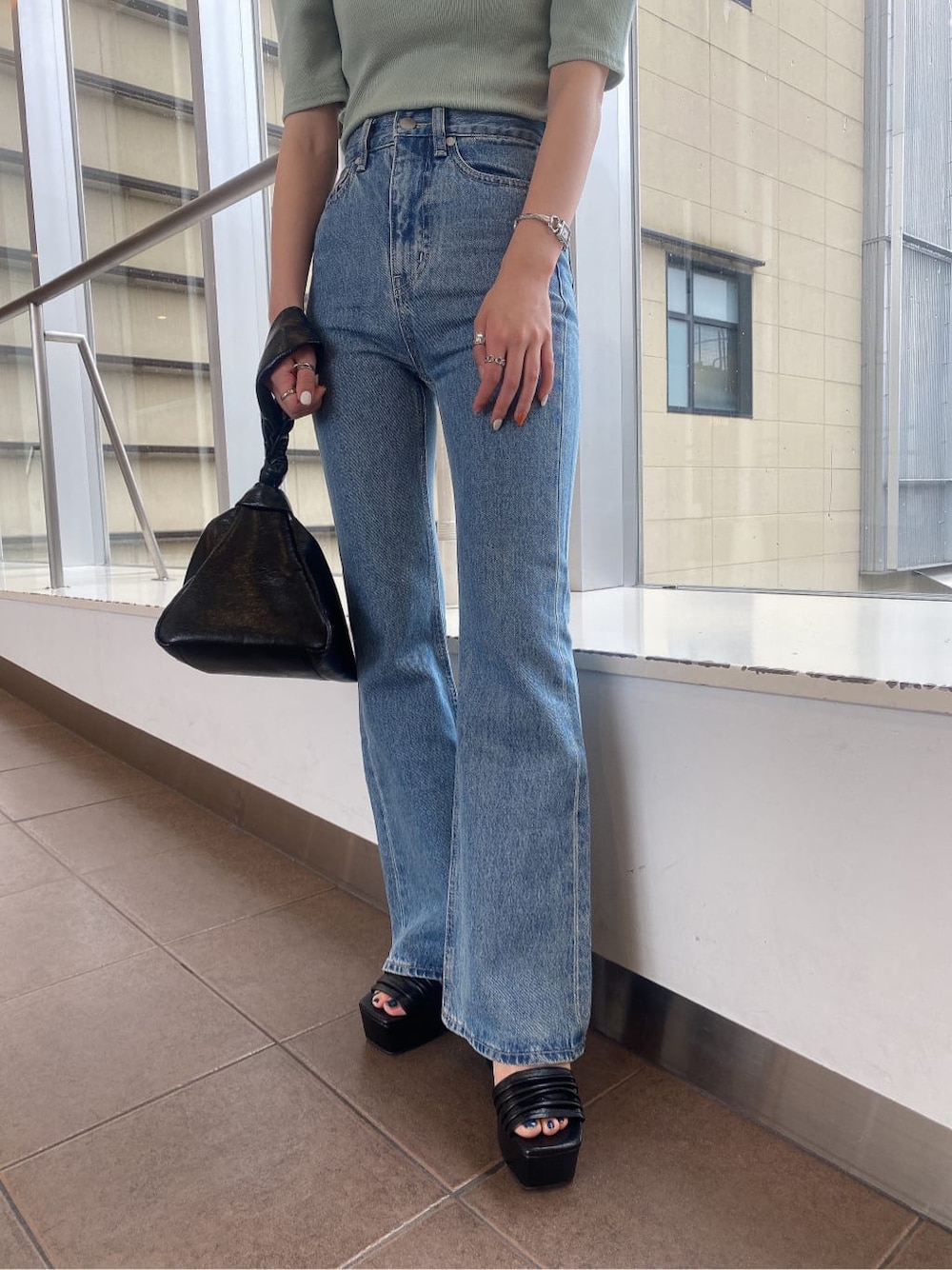 ブラック系のサンダル、グリーン系のTシャツ/カットソー、ブラック系のハンドバッグを着用したレディースの夏コーディネートの4枚目の写真