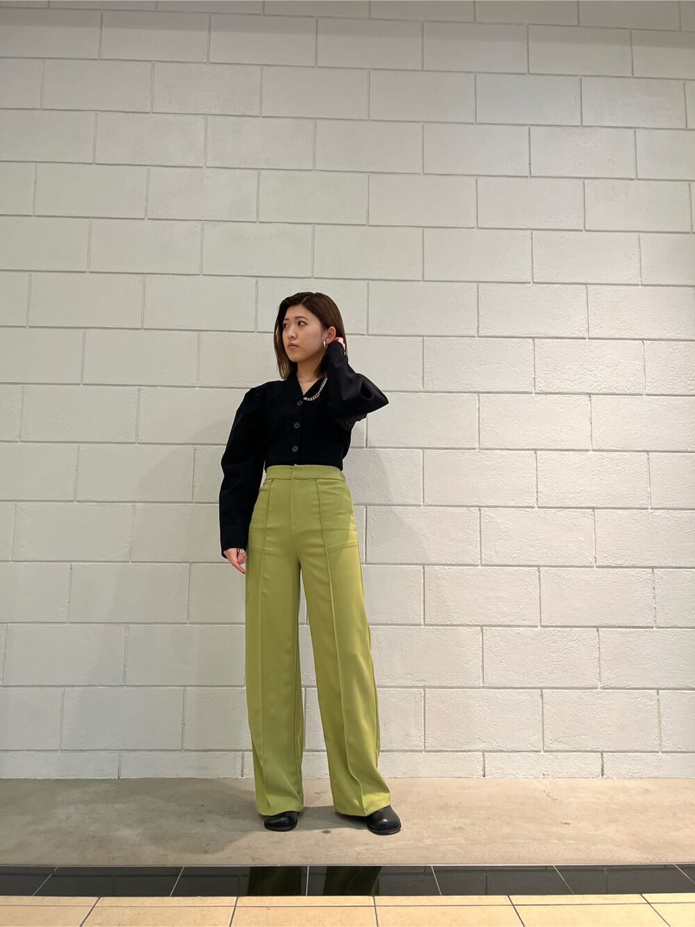 イエロー系のその他パンツ、ブラック系のTシャツ/カットソー、ブラック系のブーツを着用したレディースの春コーディネートの10枚目の写真