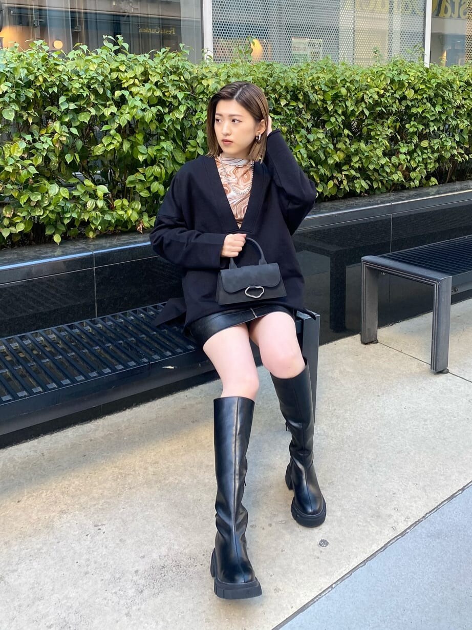 ブラック系のスカート、その他のTシャツ/カットソー、ブラック系のブーツを着用したレディースの冬コーディネートの4枚目の写真