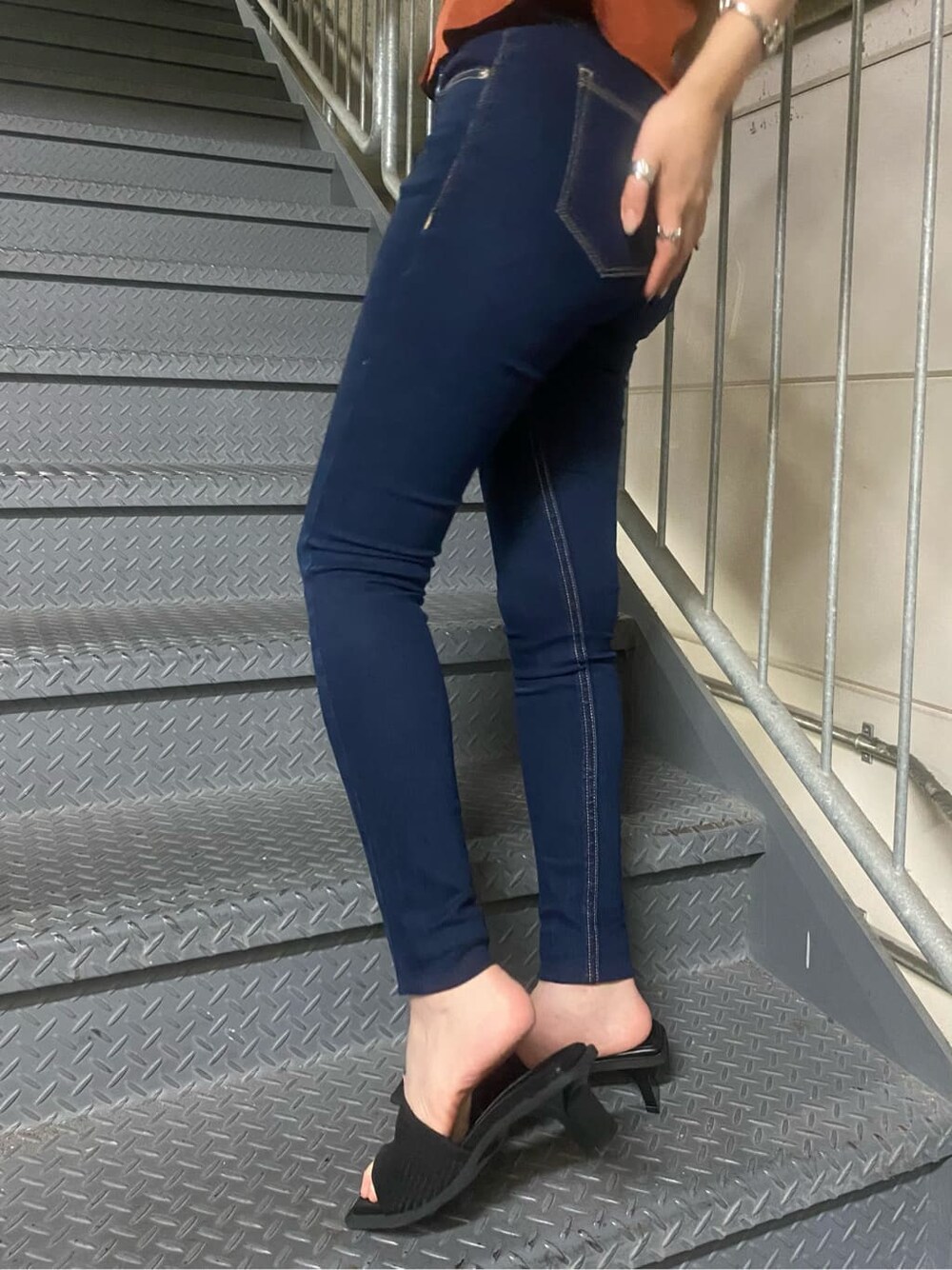 ブラック系のサンダル、ブルー系のデニムパンツを着用したレディースの夏コーディネートの5枚目の写真