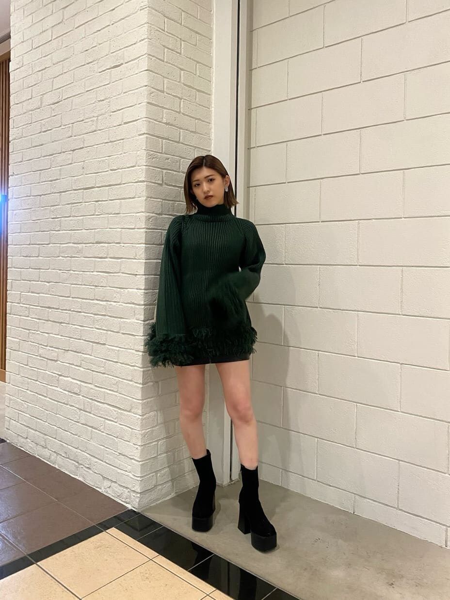 ブラック系のスカート、ブラック系のショルダーバッグ、ブラック系のブーツを着用したレディースの冬コーディネートの3枚目の写真