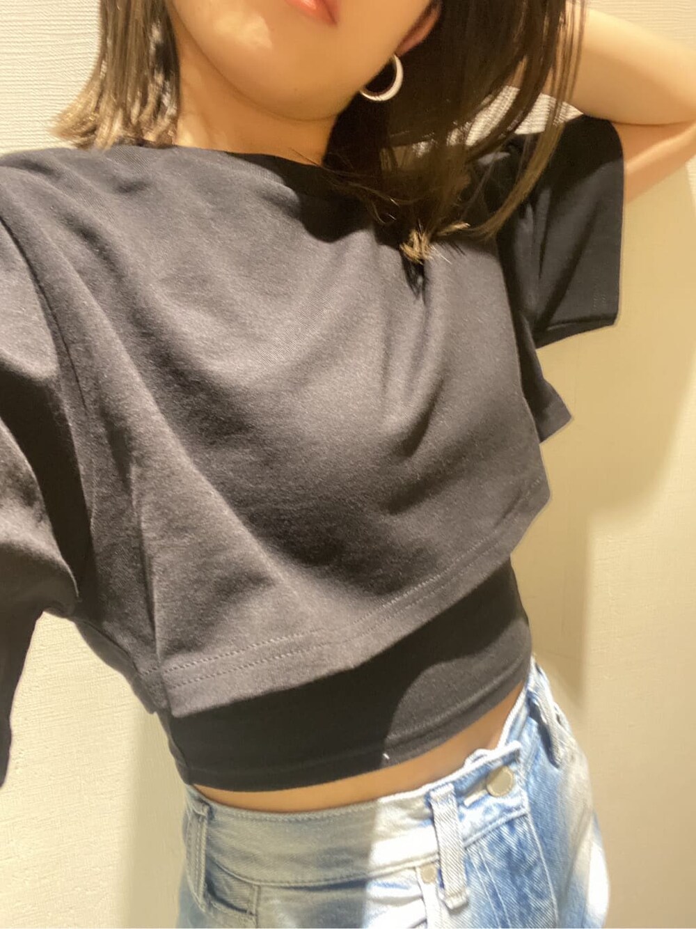 ブラック系のサンダル、ブラック系のTシャツ/カットソー、ブルー系のデニムパンツを着用したレディースの春コーディネートの6枚目の写真