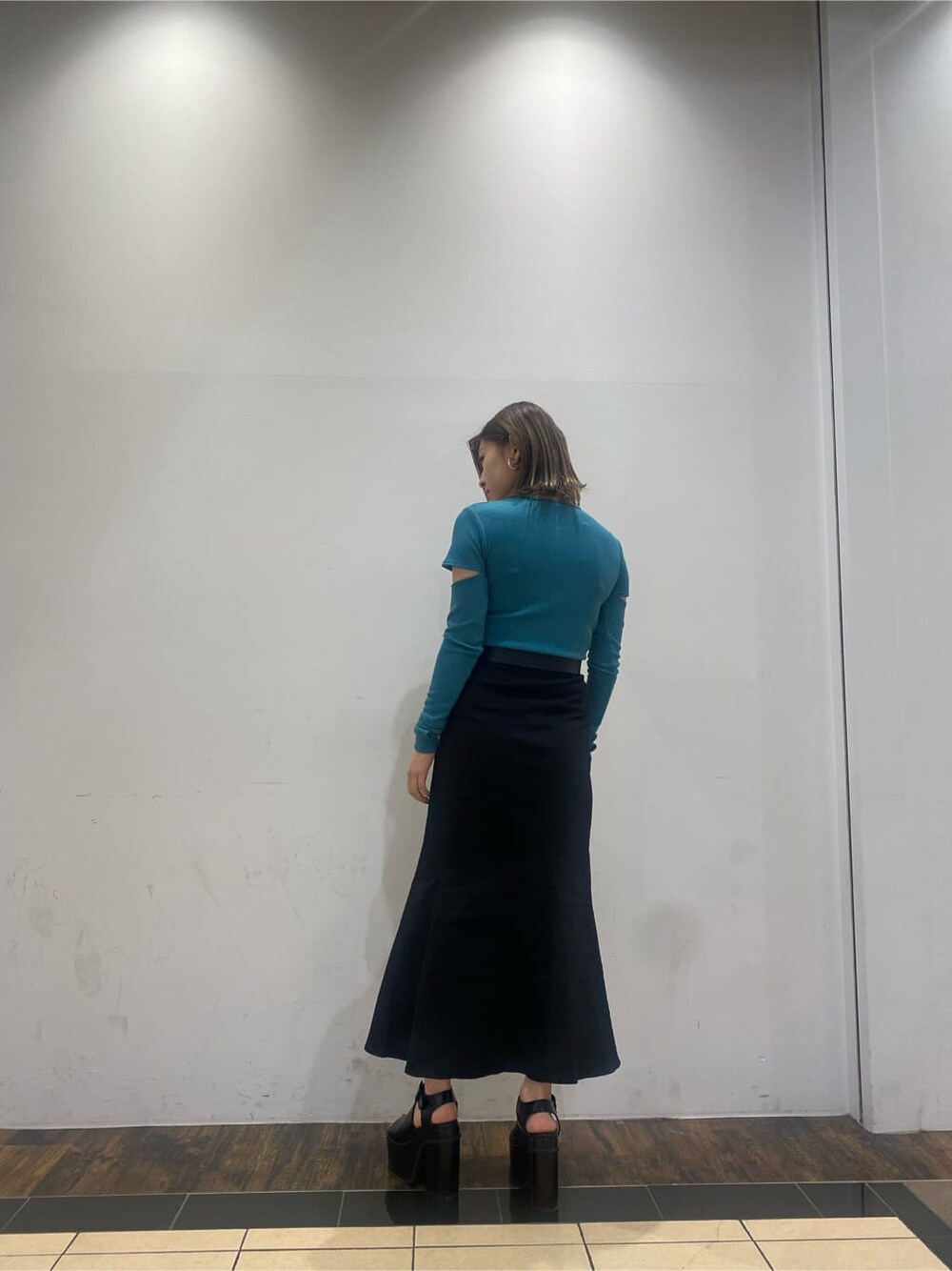 ブラック系のスカート、ブラック系のサンダル、ブルー系のTシャツ/カットソーを着用したレディースの春コーディネートの3枚目の写真