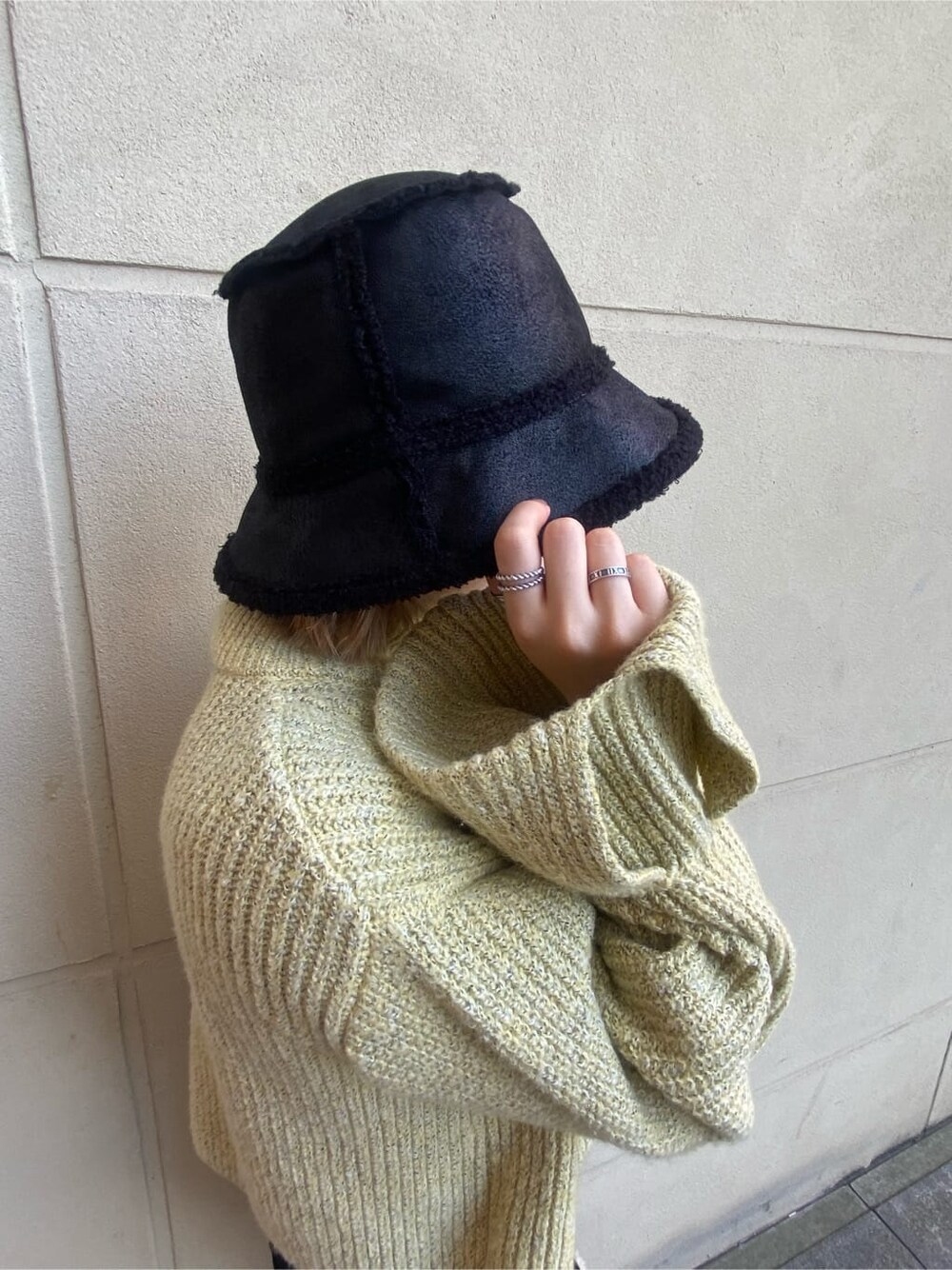 ブラック系のブーツ、ブラック系のハンドバッグ、イエロー系のニット/セーターを着用したレディースの秋コーディネートの6枚目の写真